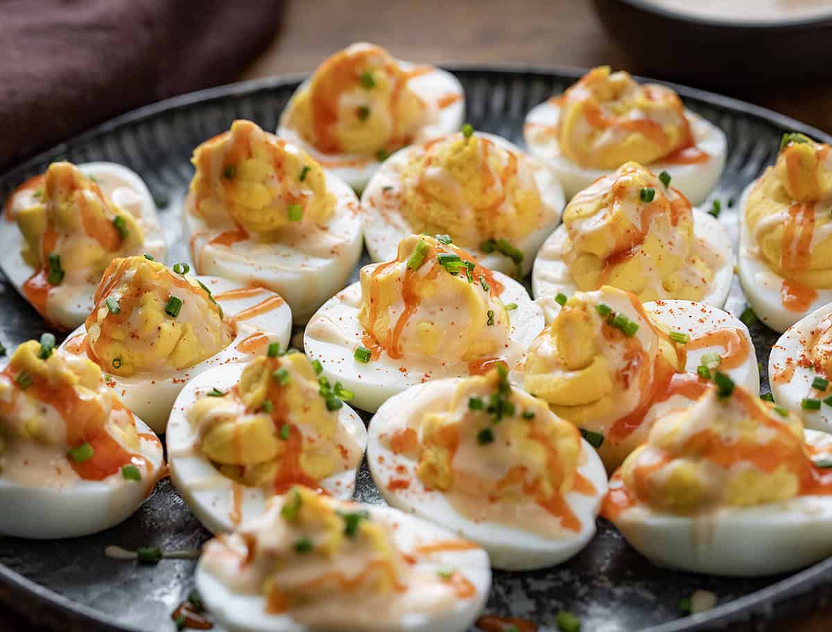 Plate of Bang Bang Deviled Eggs on a wooden table.